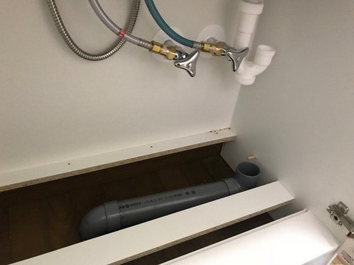 排水の塩ビ管は位置がかなりずれているので洗面化粧台の下のスペースで配管を横引きして接続します。